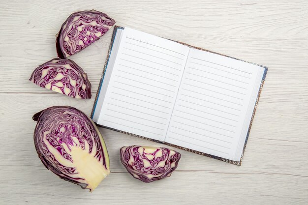 Top view cut red cabbage notebook on wooden table