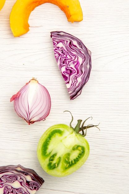 Free Photo top view cut vegetables red cabbage green tomato pumpkin red onion on white surface