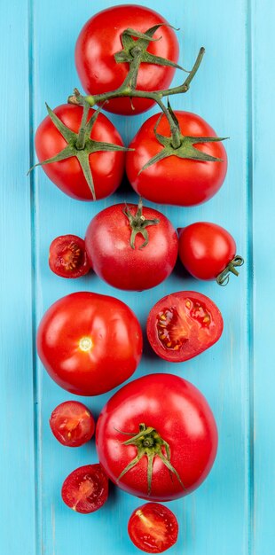 Top view of cut and whole tomatoes on blue