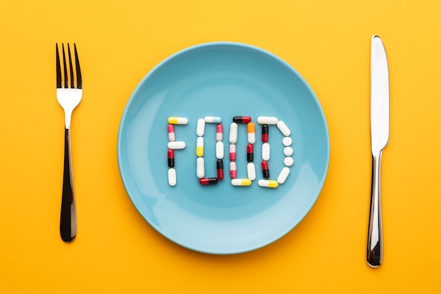 Free photo top view cutlery and food pills