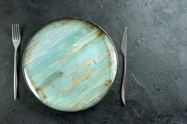 Free photo top view cyan round plate fork and knife on dark surface copy place