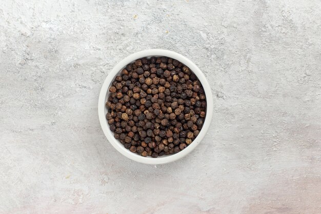 Top view dark pepper hot and spicy inside pot on white surface spice hot pepper ingredient product