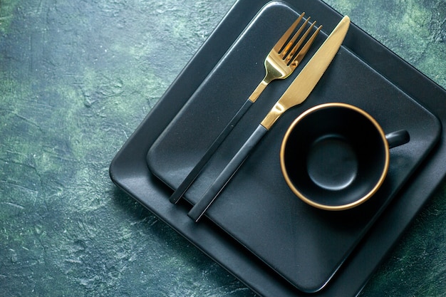 top view dark square plates with golden fork knife and cup on dark background cutlery restaurant lunch color plate tea drink