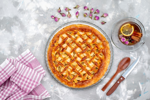 A top view delicious apple cake with hot tea and flowers cake biscuit sugar  tea