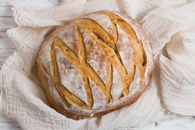 Top view delicious baked bread on white cloth