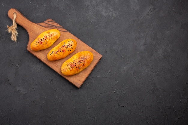 Free photo top view delicious baked patties fresh off the oven on a dark background pie pastry dough oven meat cake bake