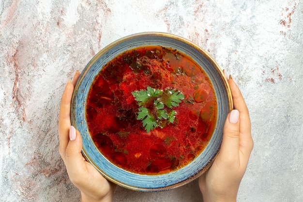 Top view delicious borsch famous ukranian beet soup with meat inside plate on a white space