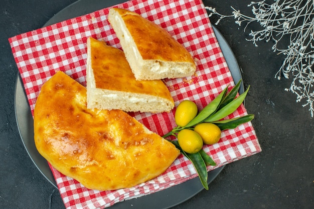 Top view of delicious bread kumquats with stem on dark surface