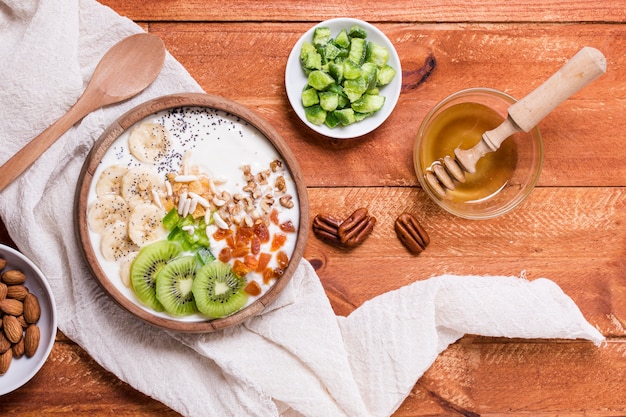 Top view delicious breakfast bowl with kiwi and yogurt