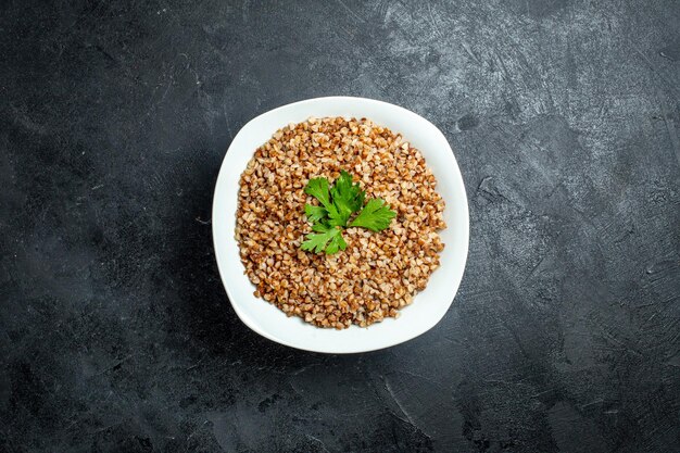 Top view delicious buckwheat meal inside plate on a grey space