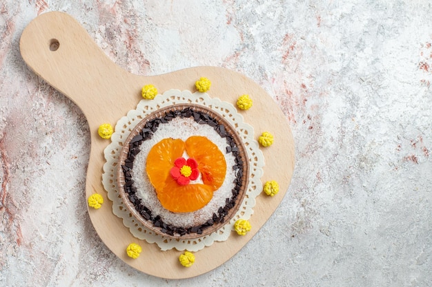 Top view delicious cake dessert with sliced tangerines on white background fruit cake dessert biscuit cream