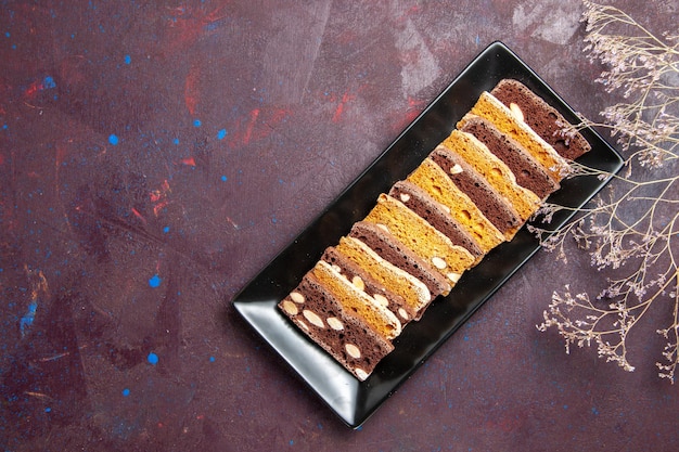 Free photo top view delicious cake slices with nuts inside cake pan on a dark background sweet tea cake sugar cookie pie biscuit