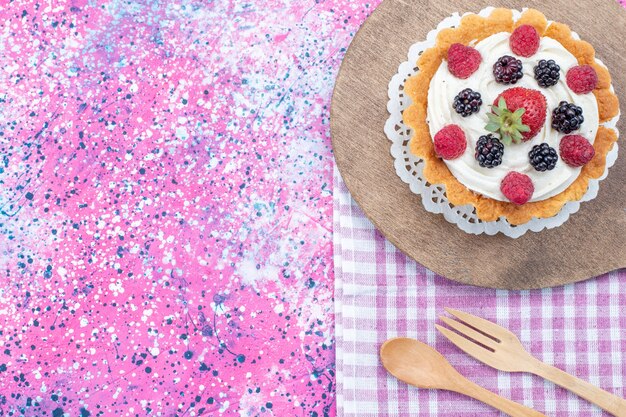 top view of delicious cake with cream and fresh berries on light desk, berry fruit cake biscuit