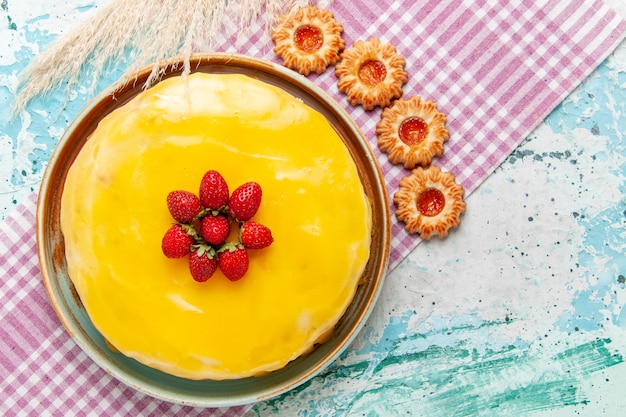 Top view delicious cake with yellow syrup fresh red strawberries and cookies on blue surface biscuit cake bake sweet sugar pie tea