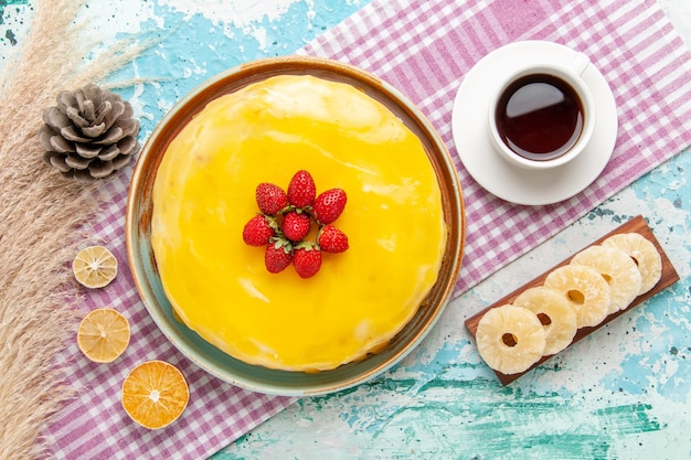 Free photo top view delicious cake with yellow syrup and fresh red strawberries on light blue desk biscuit cake bake sweet sugar pie tea