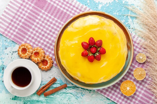 Top view delicious cake with yellow syrup and fresh red strawberries on the light-blue surface biscuit cake bake sweet sugar pie tea