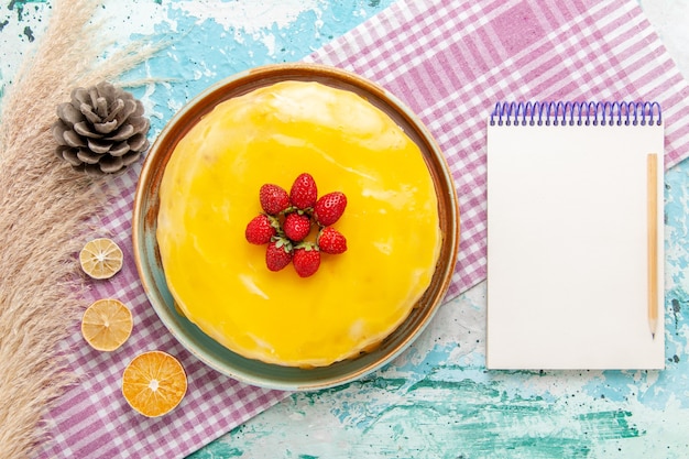 Free photo top view delicious cake with yellow syrup and fresh red strawberries on the light blue surface biscuit cake bake sweet sugar pie tea