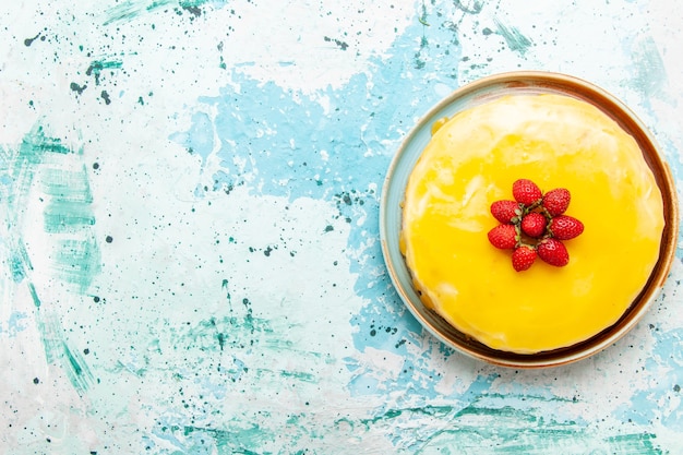 Top view delicious cake with yellow syrup and red strawberries on the blue desk biscuit cake sweet pie sugar tea