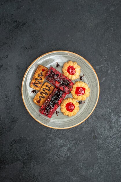 Top view delicious cakes fruity sweets with cookies on a dark background tea cookie biscuit pie cake sweet