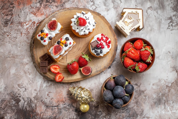 Top view delicious cakes with fresh fruits on light background