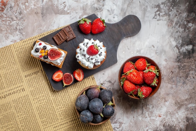 Free photo top view delicious cakes with fresh fruits on light background