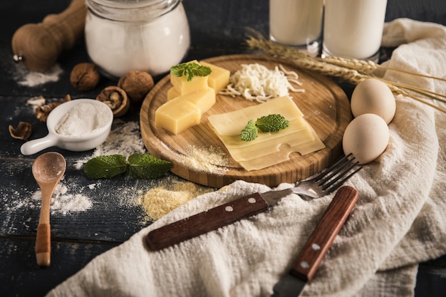 Top view of a delicious cheese platter with milk, flour, and eggs on a table