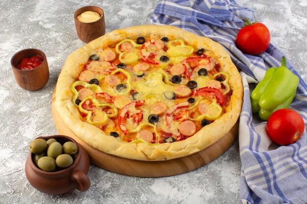 Top view delicious cheesy pizza with olives sausages and tomatoes on the grey background fast-food dough food meal