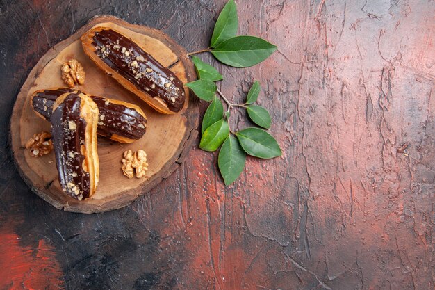 Free photo top view delicious choco eclairs on dark table cake sweet dessert