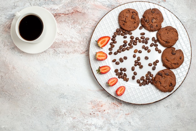 Top view delicious chocolate cookies with chocolate chips coffee and strawberries on white background biscuit sugar sweet cake cookies