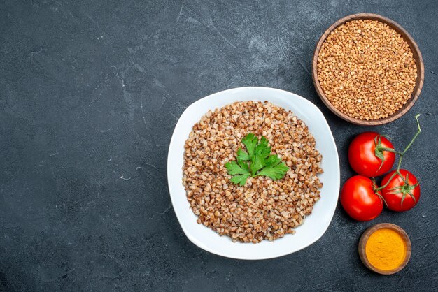 Top view delicious cooked buckwheat with fresh tomatoes on grey space