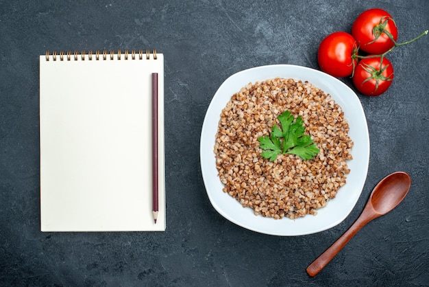 Top view delicious cooked buckwheat with tomatoes on grey space