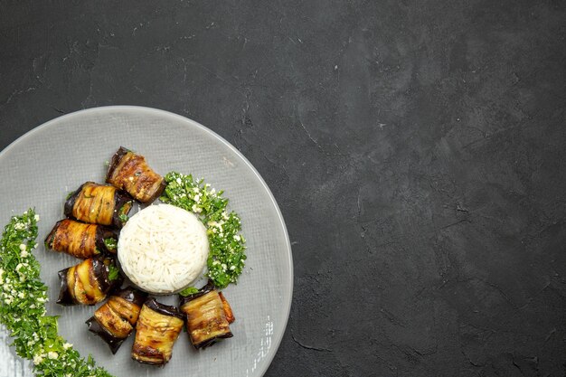 Top view delicious cooked eggplants with greens and rice on dark surface dinner food cooking oil rice meal