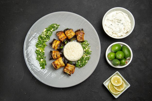 Top view delicious cooked eggplants with rice lemon and feijoa on dark surface dinner food cooking oil rice meal