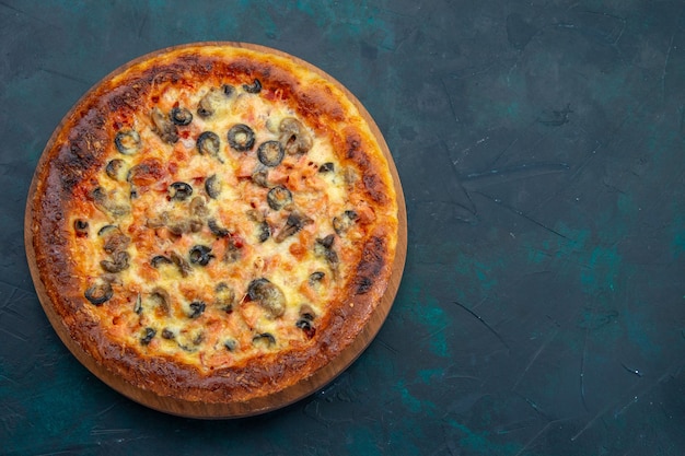 Top view of delicious cooked pizza with cheese and olives on dark blue desk