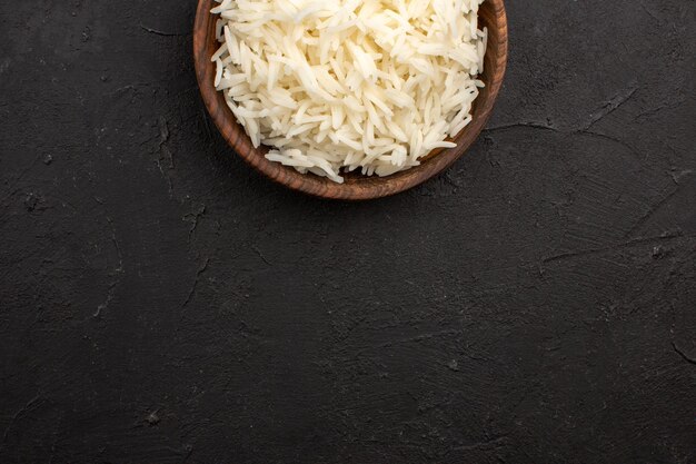 Top view delicious cooked rice plain tasty rice inside brown plate on dark space