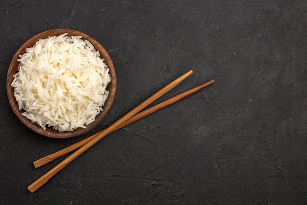 Top view delicious cooked rice plain tasty rice inside brown plate on dark space