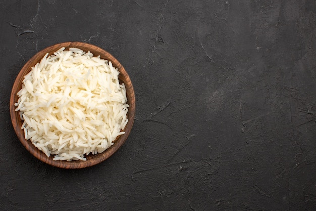 Free Photo top view delicious cooked rice plain tasty rice inside brown plate on the dark space