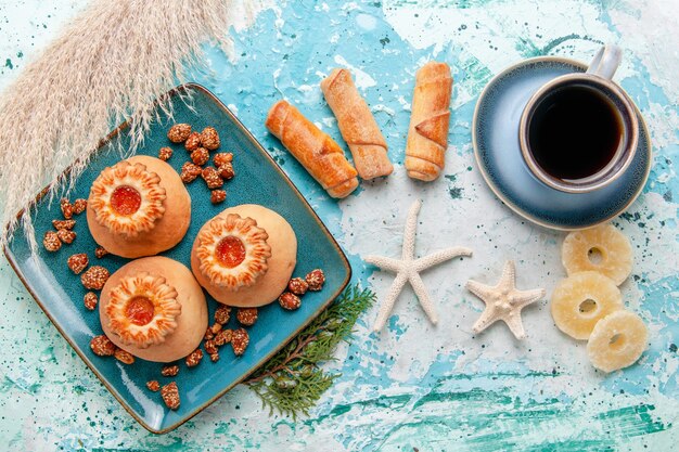 Top view delicious cookies with dried pineapple rings and coffee on light blue desk cookie biscuit sweet sugar color