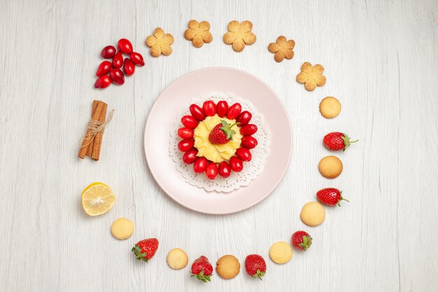 Top view delicious cookies with fruits and cake on white desk