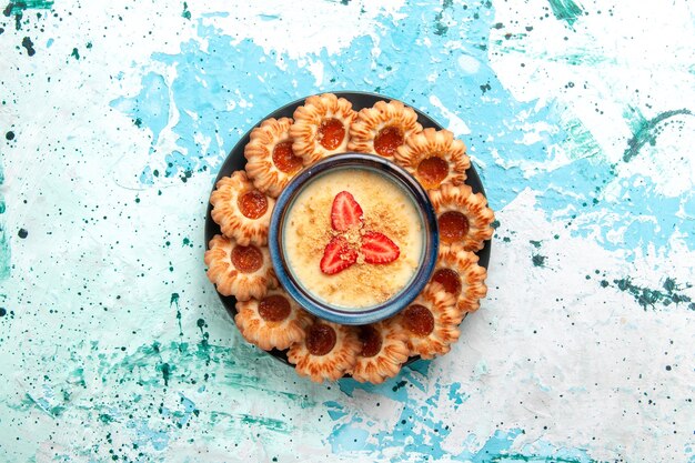 Top view delicious cookies with jam and strawberry dessert on light-blue surface cookie sugar sweet biscuit cake