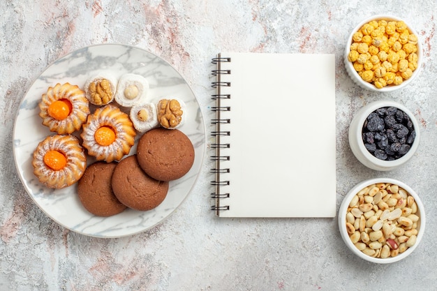 Top view delicious cookies with nuts and raisins on a white background nut cookie sweet cake sugar