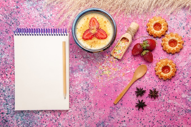 Free Photo top view delicious creamy dessert with red sliced strawberries notepad and little cookies on light-pink background dessert ice-cream berry cream sweet fruit