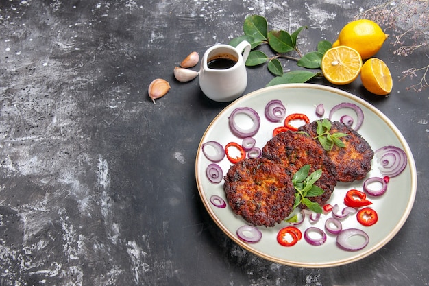 Free photo top view delicious cutlets with onion rings