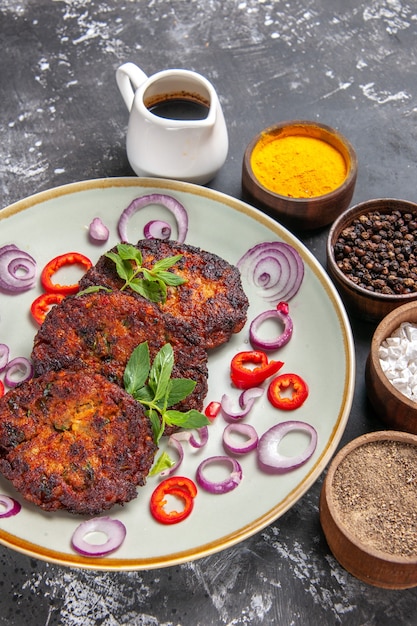 Free photo top view delicious cutlets with onion rings