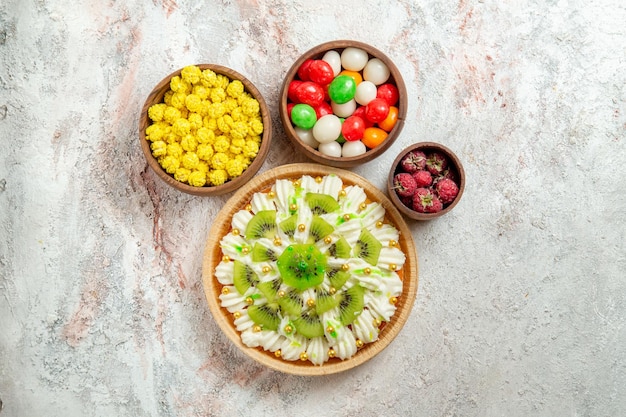 Top view delicious dessert with white cream and candies on white background dessert cream cake fruit