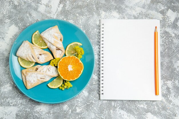 Top view delicious dough pastries with lemon slices on white background pastry sugar bake cake dough sweet pie