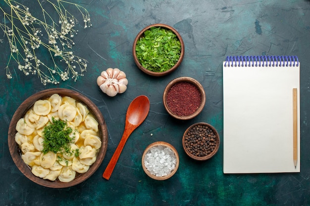 Free photo top view delicious dumpling soup with different seasonings on dark green desk soup food meat vegetable dough