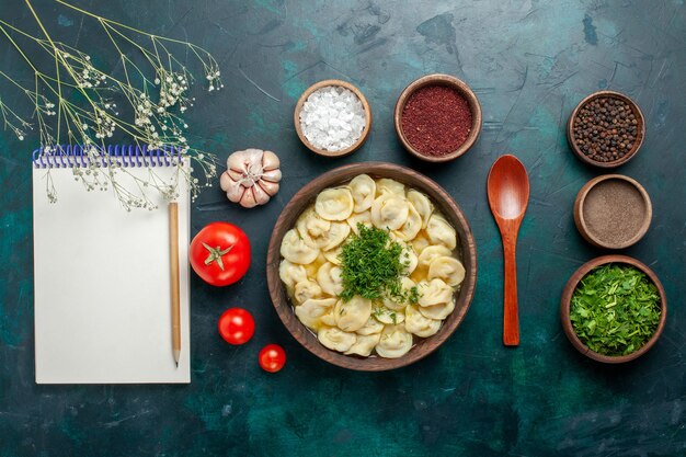 Top view delicious dumpling soup with different seasonings on green desk soup meat dough vegetable food