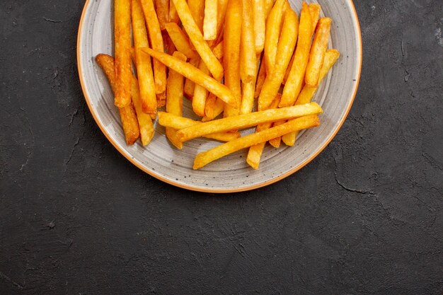 Top view delicious french fries inside plate on dark background potatoes burger meal sandwich dinner dish