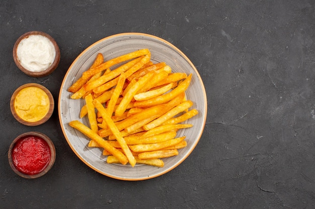 Top view delicious french fries with seasonings on dark background potato meal burger fast-food dish